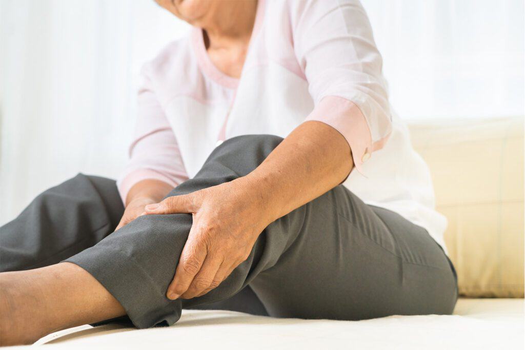 older woman holding her calf in pain from Deep Vein Thrombosis