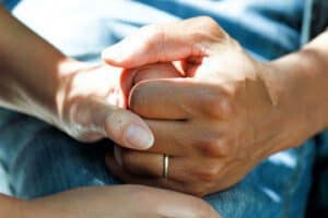 clasped hands offering comfort and support