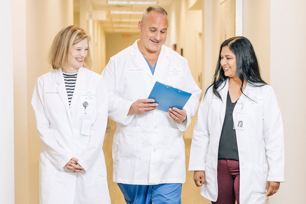 Three doctors walking down a hallway