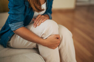 Woman holding aching knee