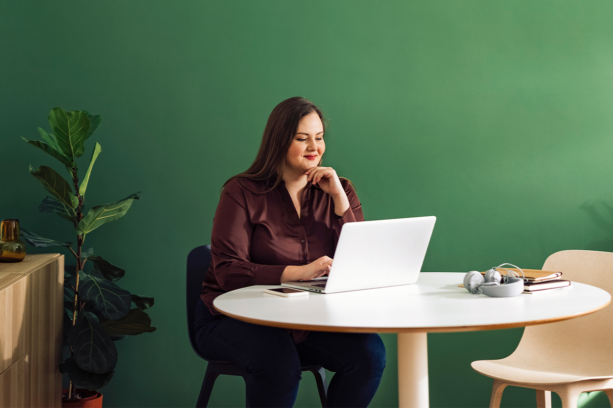 Woman sitting at table on her laptop