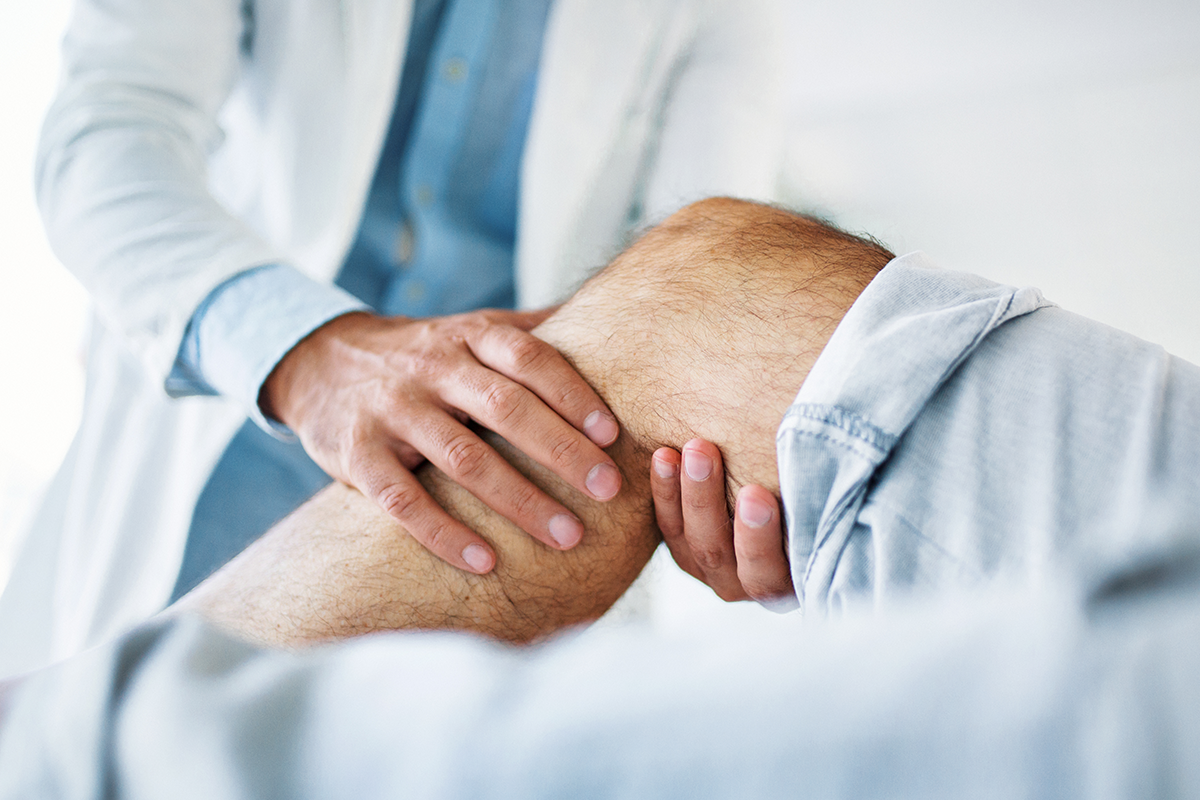 Physician checking patient's knee
