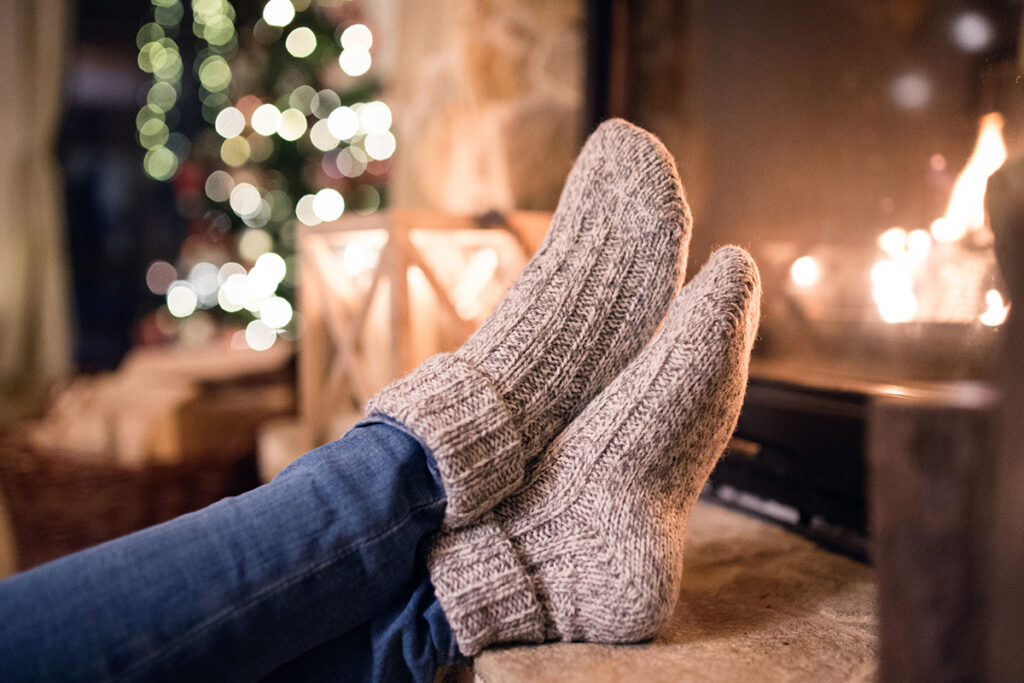 Person leaning their feet near the fire with wool socks