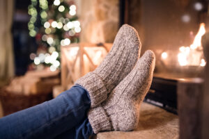 Person leaning their feet near the fire with wool socks