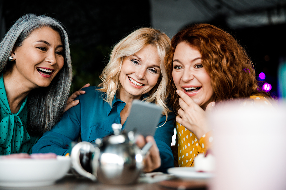 Three women sitting around a table laughing