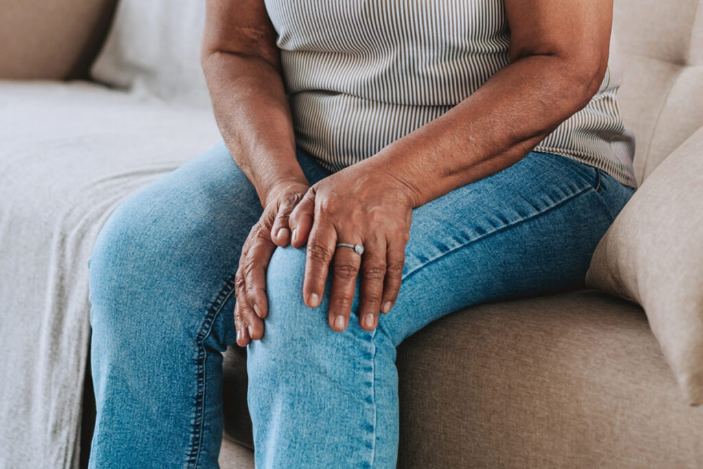 Woman holds knee in pain