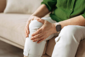 Man holding knee while sitting on couch